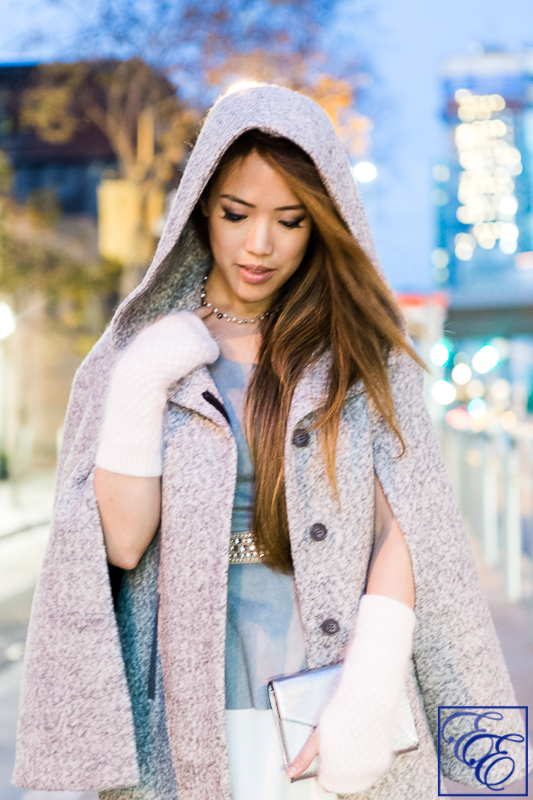 Light grey cape, peplum top, white flared skirt, grey hosiery, arm warmers, and metallic pumps and clutch: close-up of cape and accessories