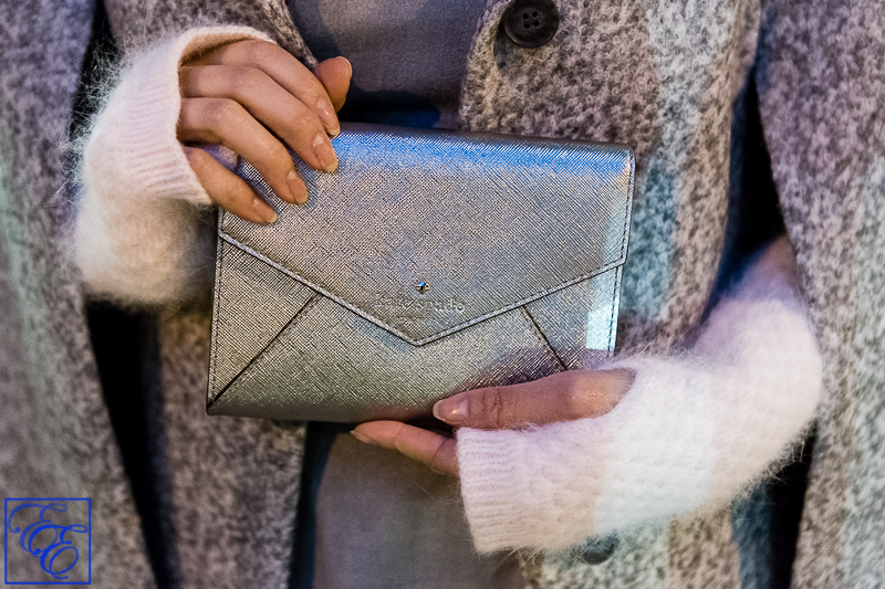 Light grey cape, peplum top, white flared skirt, grey hosiery, arm warmers, and metallic pumps and clutch: close-up of cape and accessories