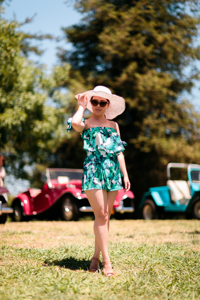 Woman wearing Tobi tropical print romper set (off-shoulder sleeves and shorts) with Hatattack sunhat and Chanel sunglasses